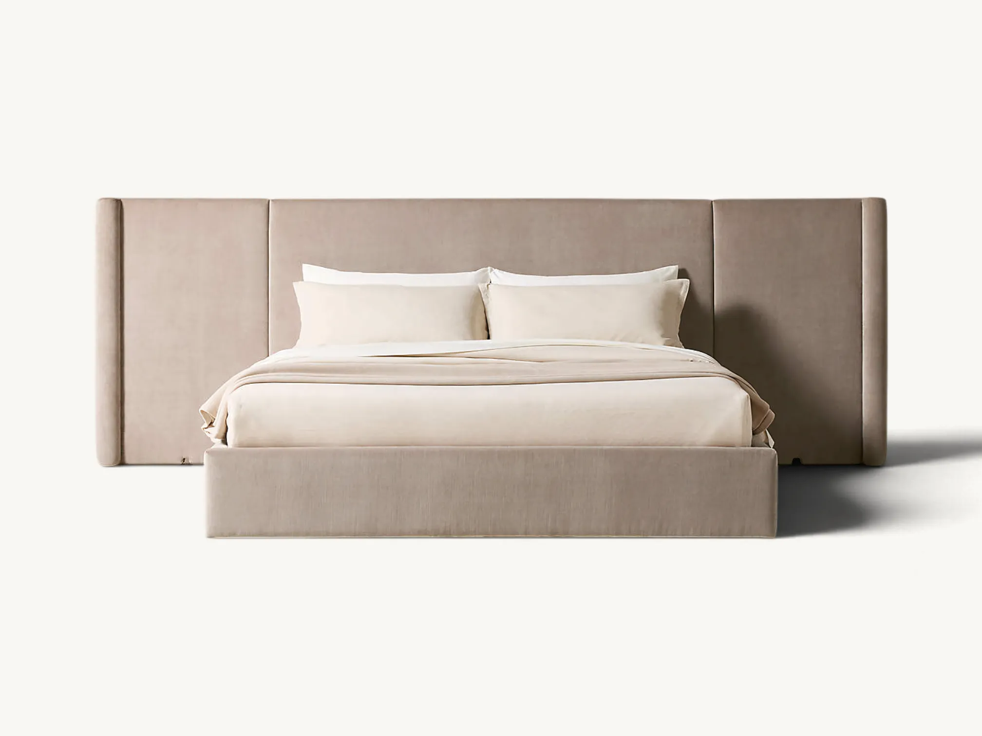 Fully upholstered platform bed frame with an extra wide extended wingback headboard in a neutral modern bedroom