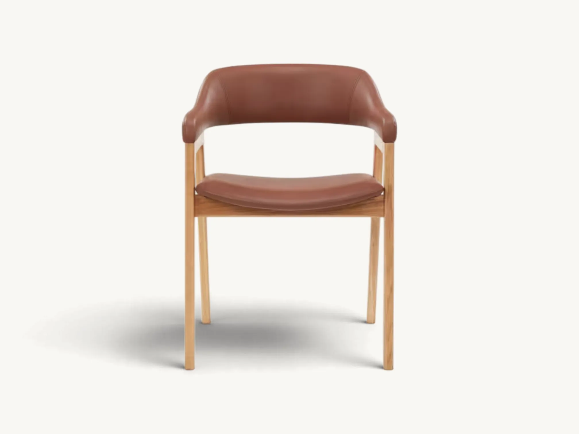Mid-Century teak wood dining chair with curved brown leather upholstered seat and tapered legs.