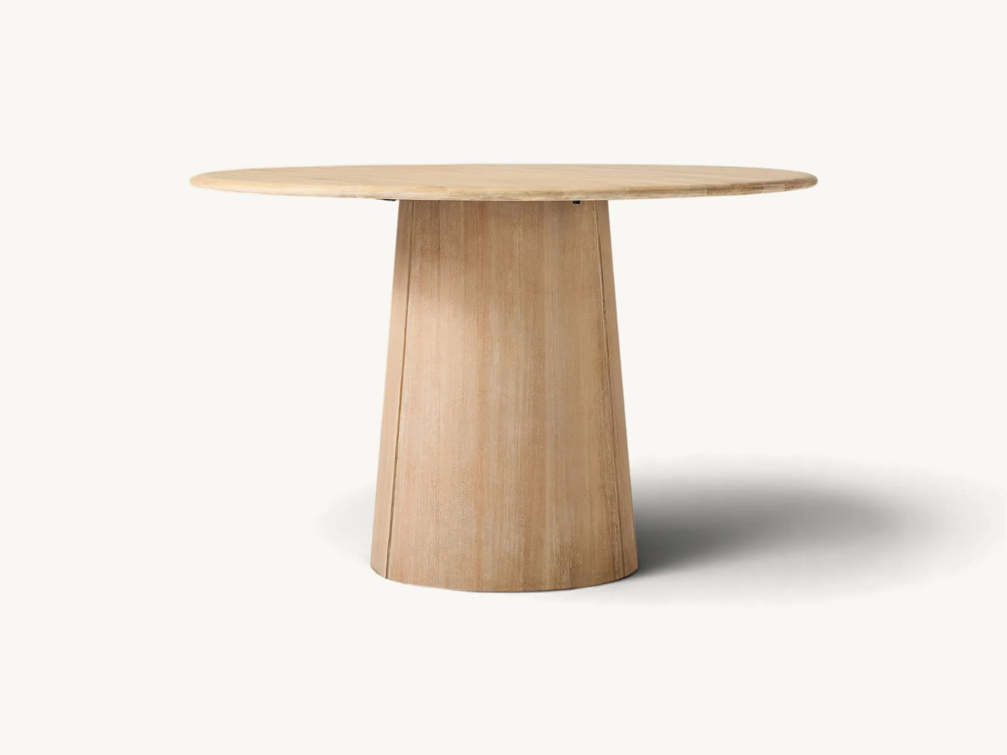 Japandi style round teak dining table with a solid tapered pedestal base.