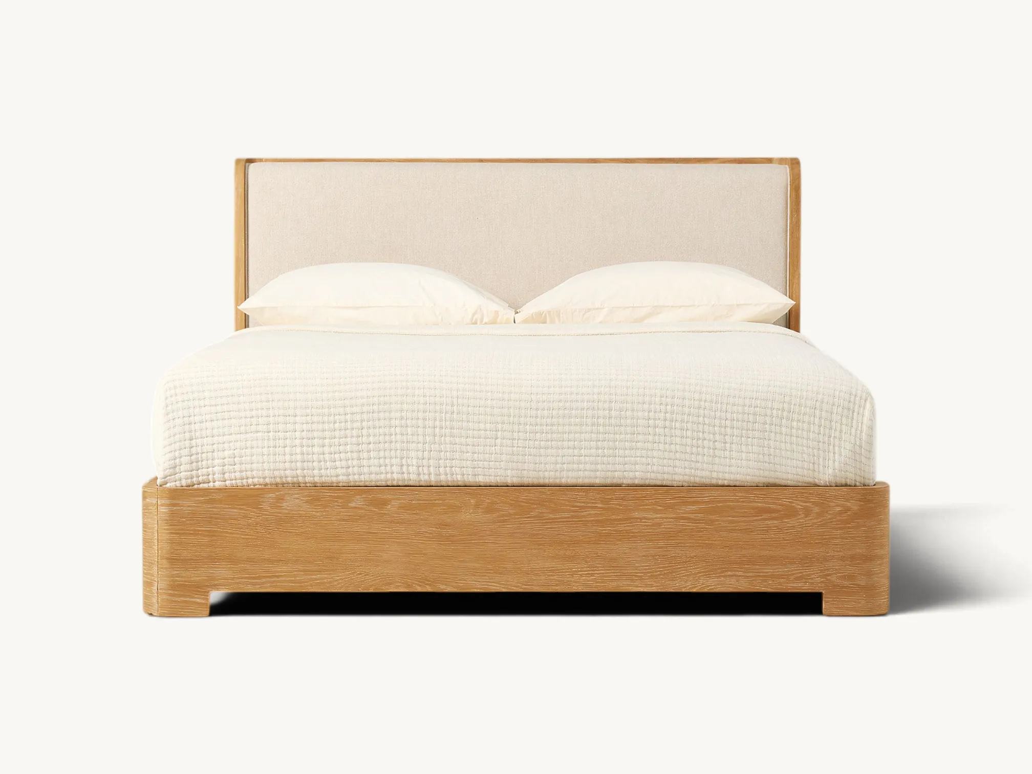 Modern teak wood bed frame with cream upholstered headboard and rounded corners.