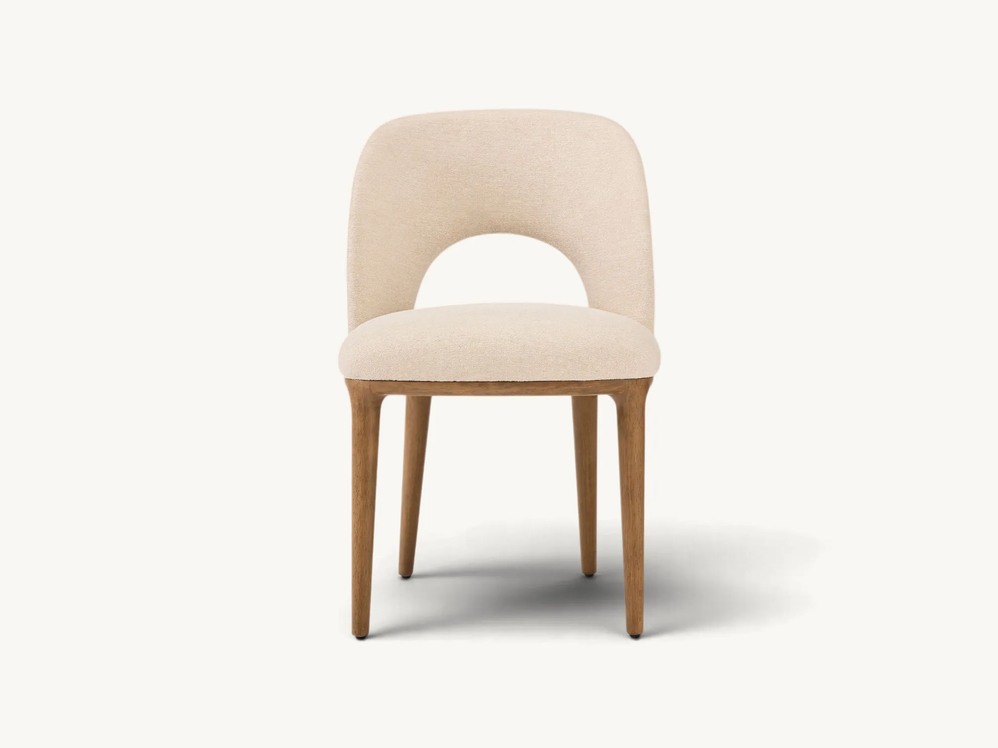 Mid-Century Modern teak dining chair with cream upholstery and curved cut-out backrest.