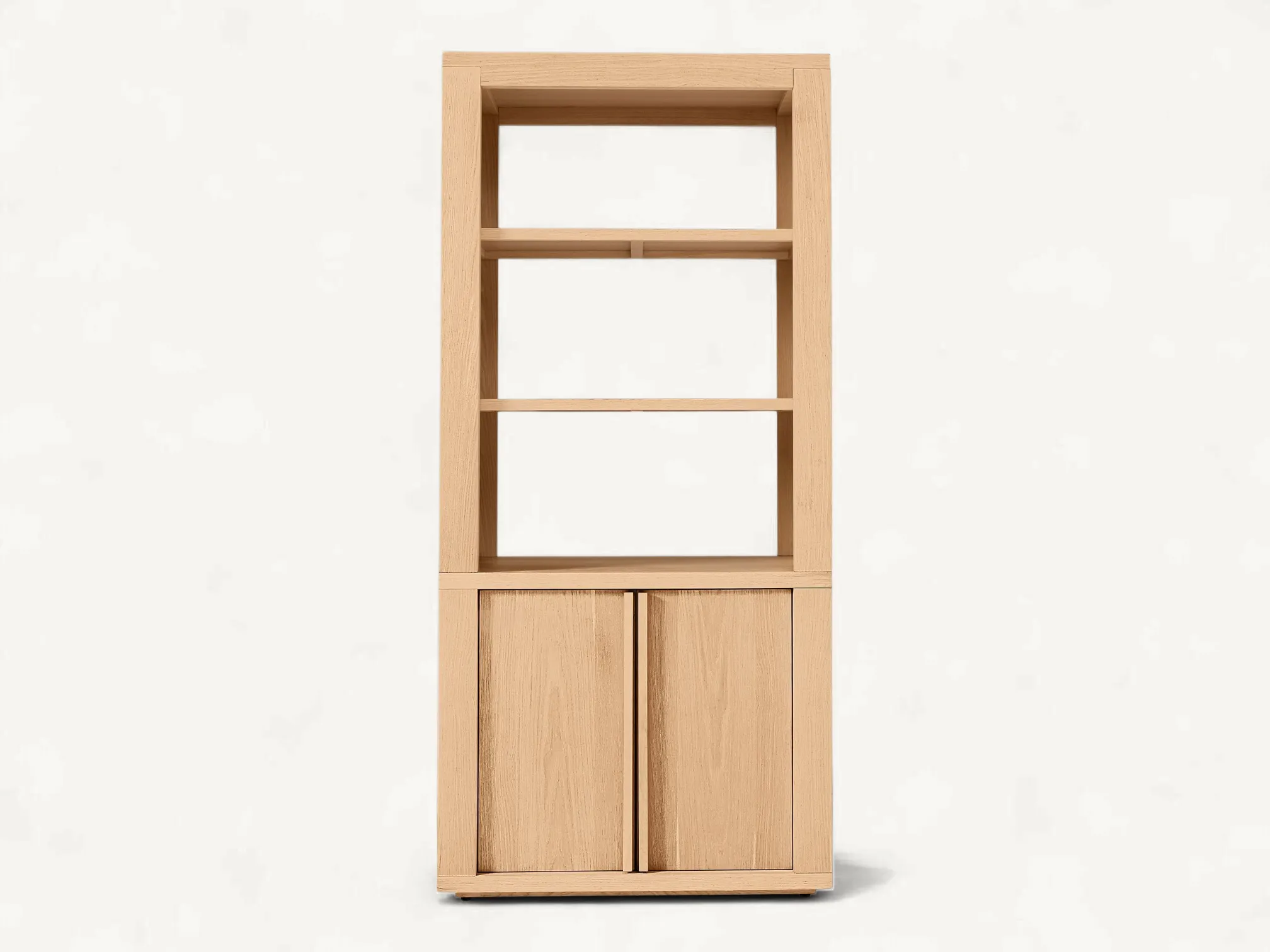 Minimalist tall teak wood bookshelf with open upper shelving and a closed double-door base cabinet featuring seamless vertical handles.