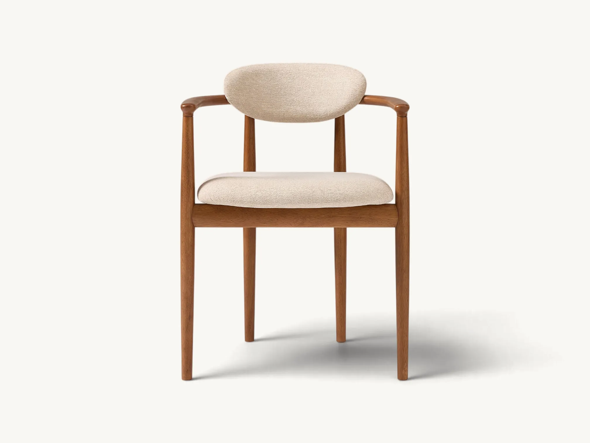 Scandinavian style teak wood dining chair with curved backrest and cream upholstery.