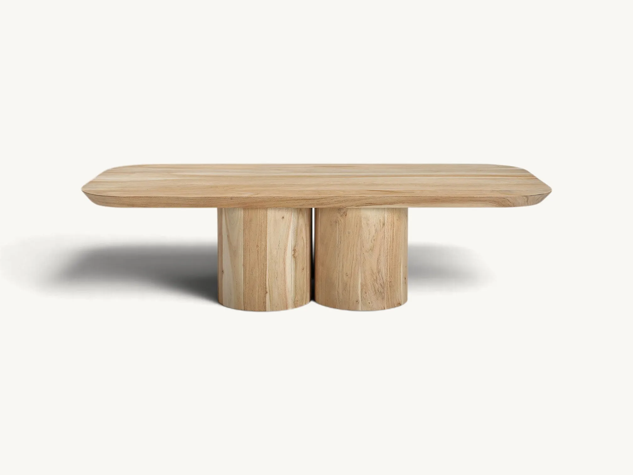 Natural teak wood coffee table with rounded rectangular top and three chunky cylindrical pillar legs on a white background.