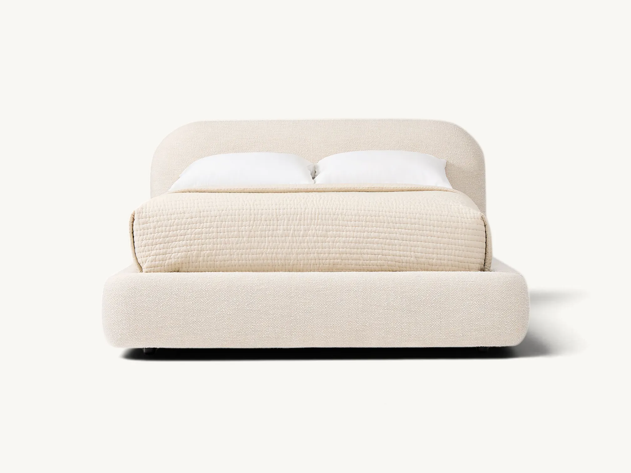Modern fully upholstered platform bed in cream fabric with rounded headboard and teak wood internal frame.