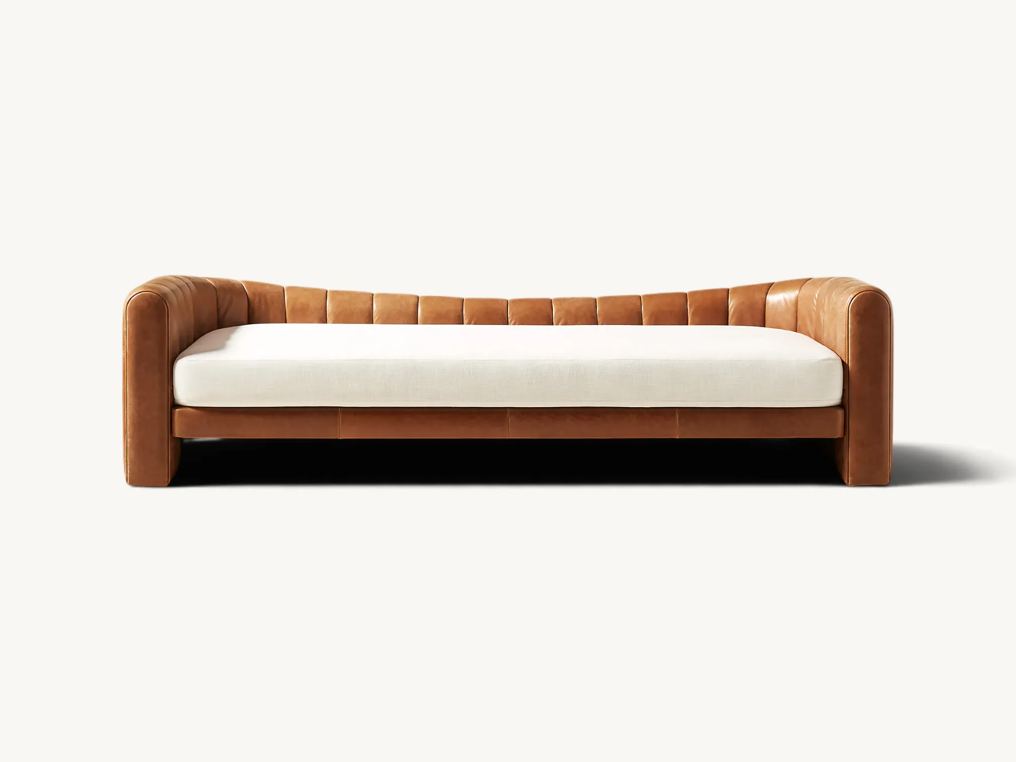 Curved leather daybed with vertical channel tufting and teak wood frame base.