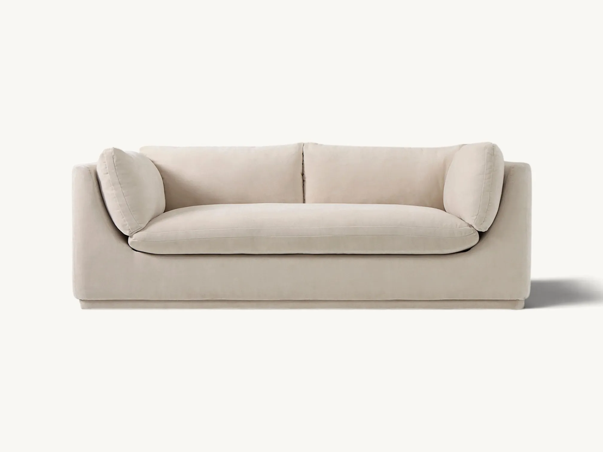 Scandinavian style sofa with curved frame and plush cream cushions in a neutral fabric.