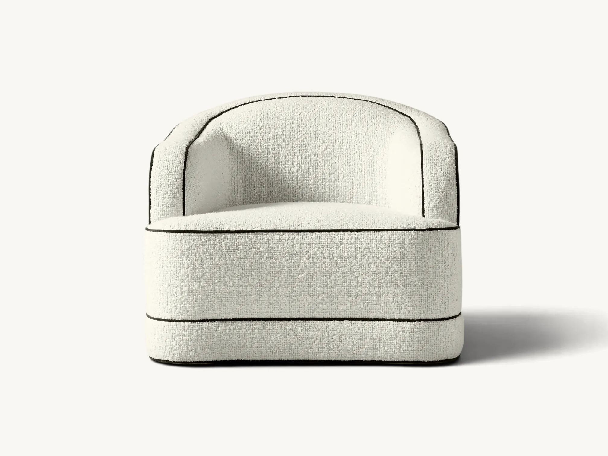 Modern curved single sofa in white bouclé fabric with black piping detail, featuring a minimalist design and premium upholstery for a cozy living room atmosphere.