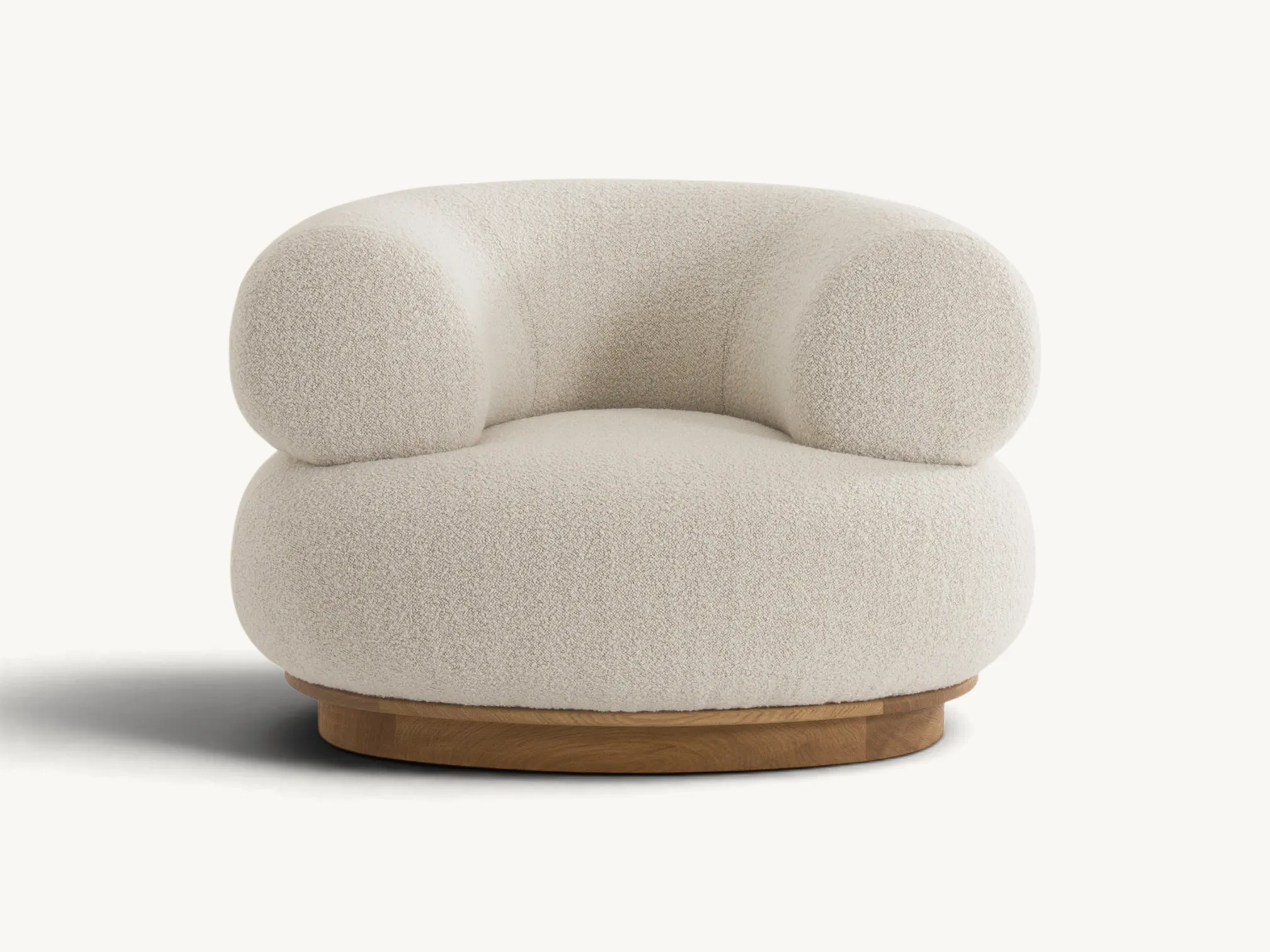 Sculptural cream bouclé armchair with a rounded, tiered silhouette and a low-profile teak wood base.