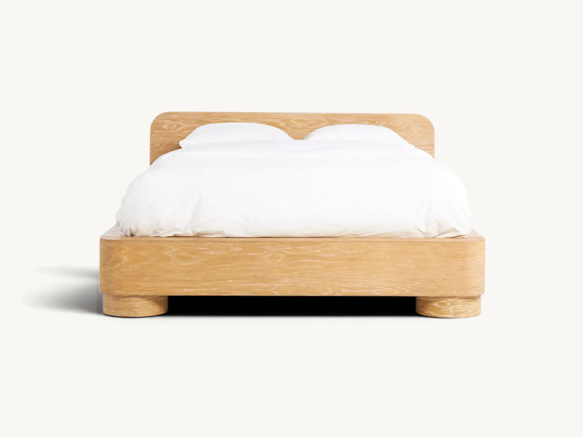 Minimalist solid teak wood bed frame with rounded corners, natural grain finish, and thick cylindrical platform legs.