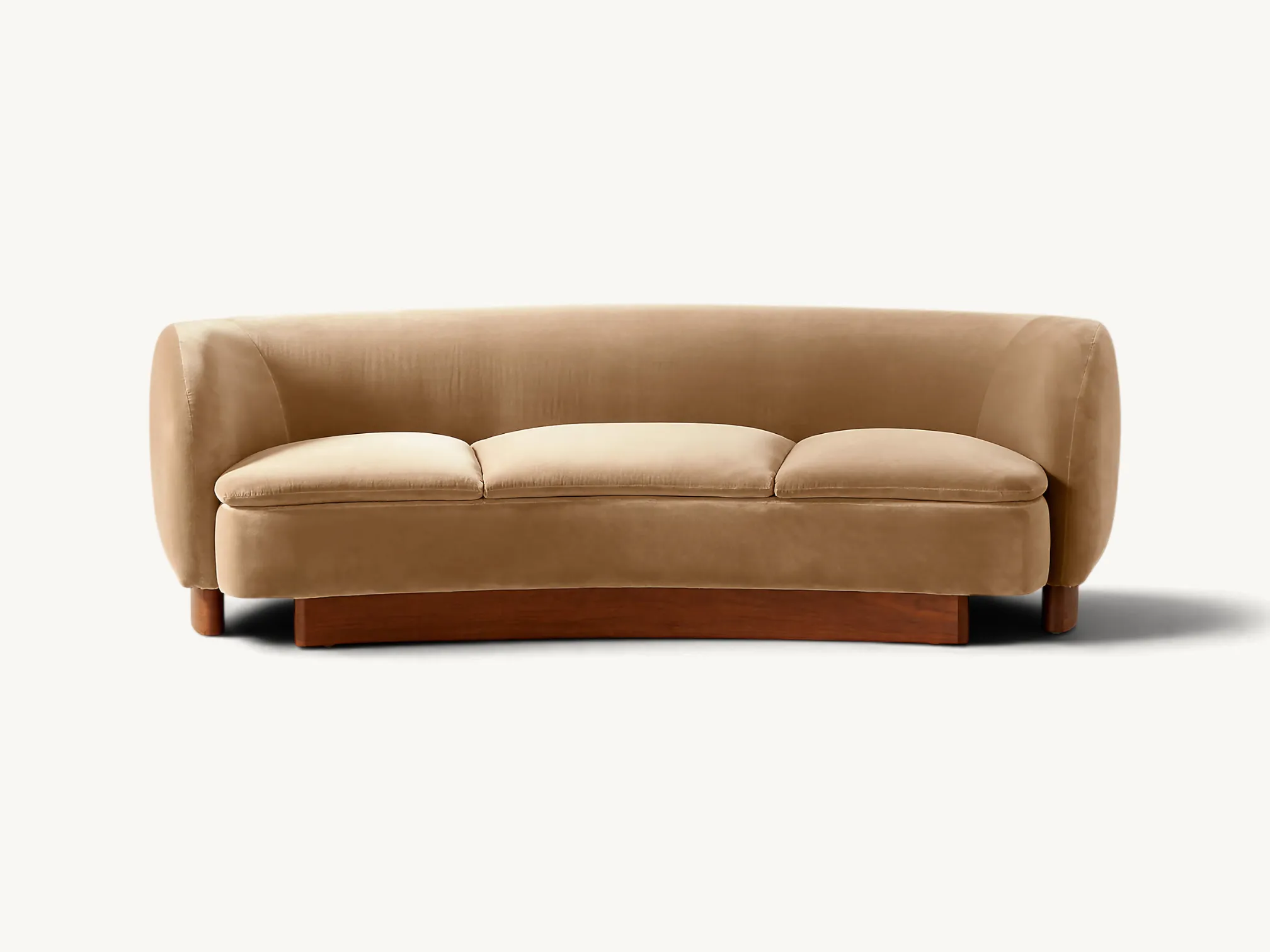 Curved velvet three-seater sofa featuring a wrap-around backrest and a solid teak wood plinth base in a mid-century modern style.
