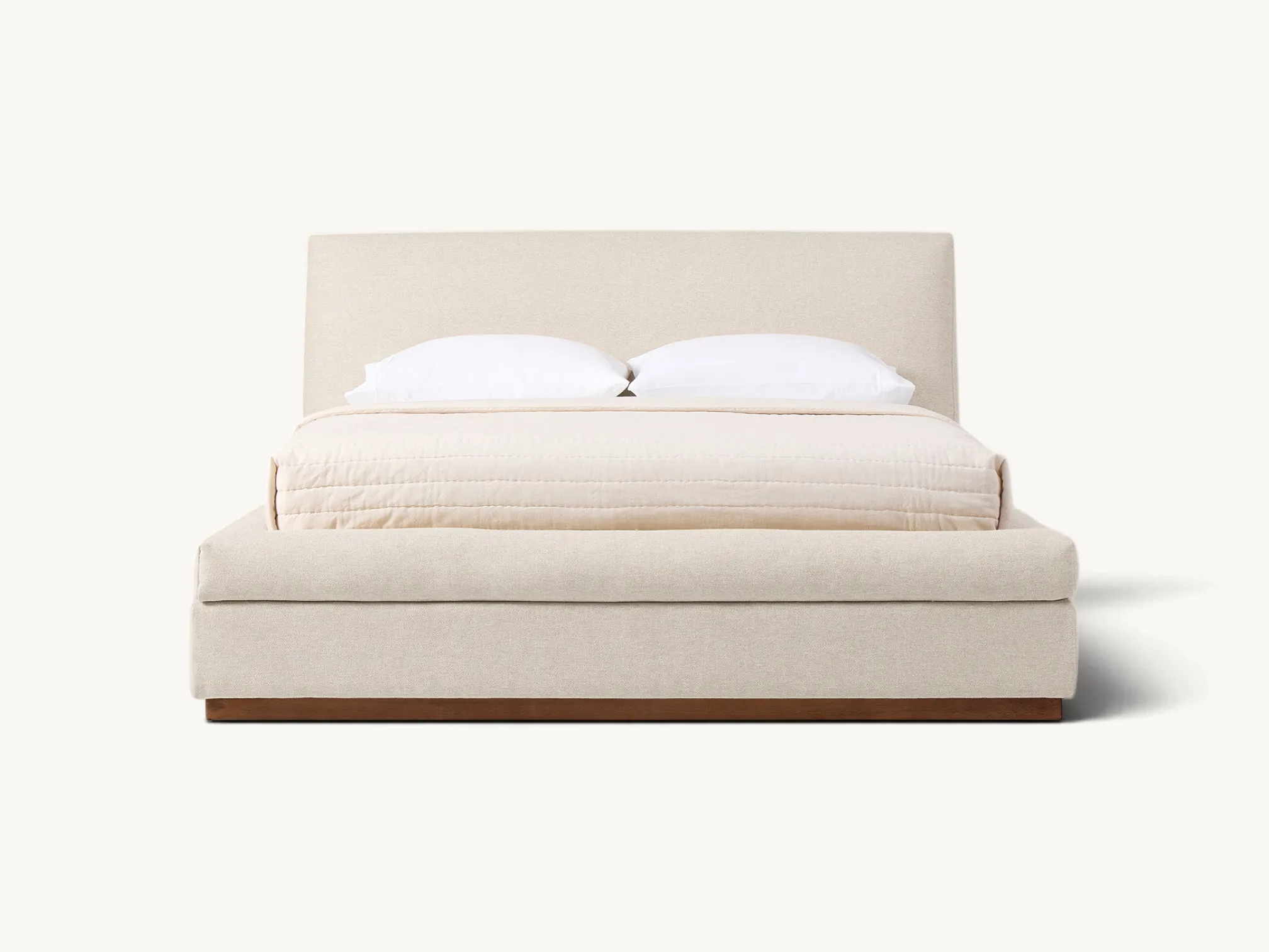 Solid wood mid-century platform bed with tapered flared legs, an angled open-back headboard holding two thick button-tufted gray fabric cushions, and an integrated wood slat support system.
