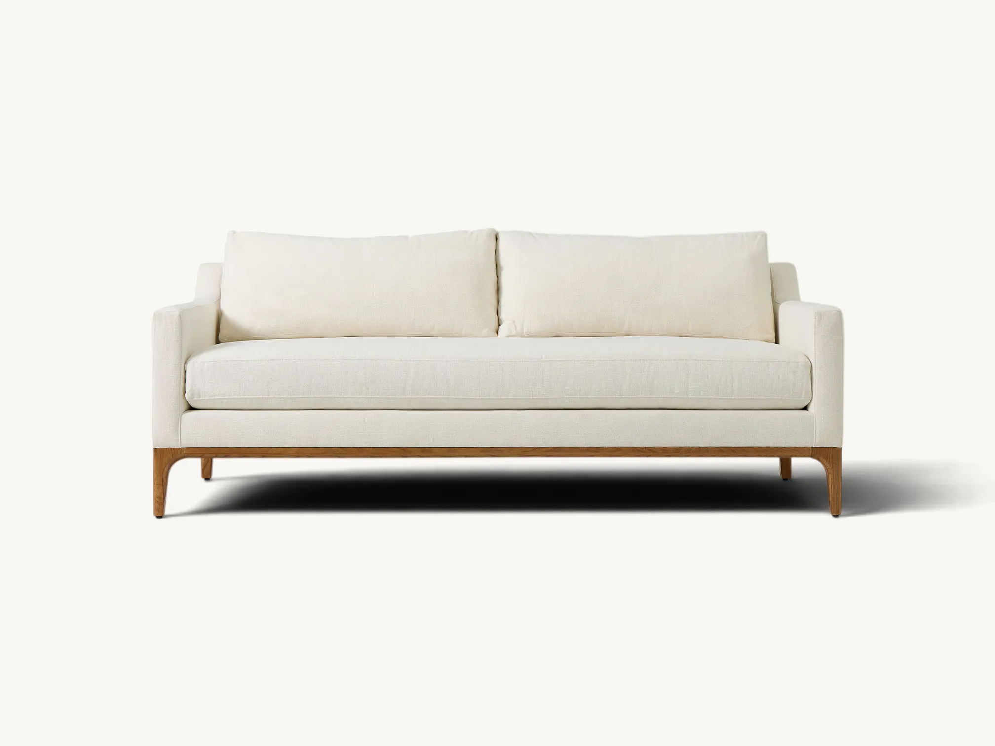 Mid-century modern sofa with natural teak wood base, tapered legs, and off-white upholstery.