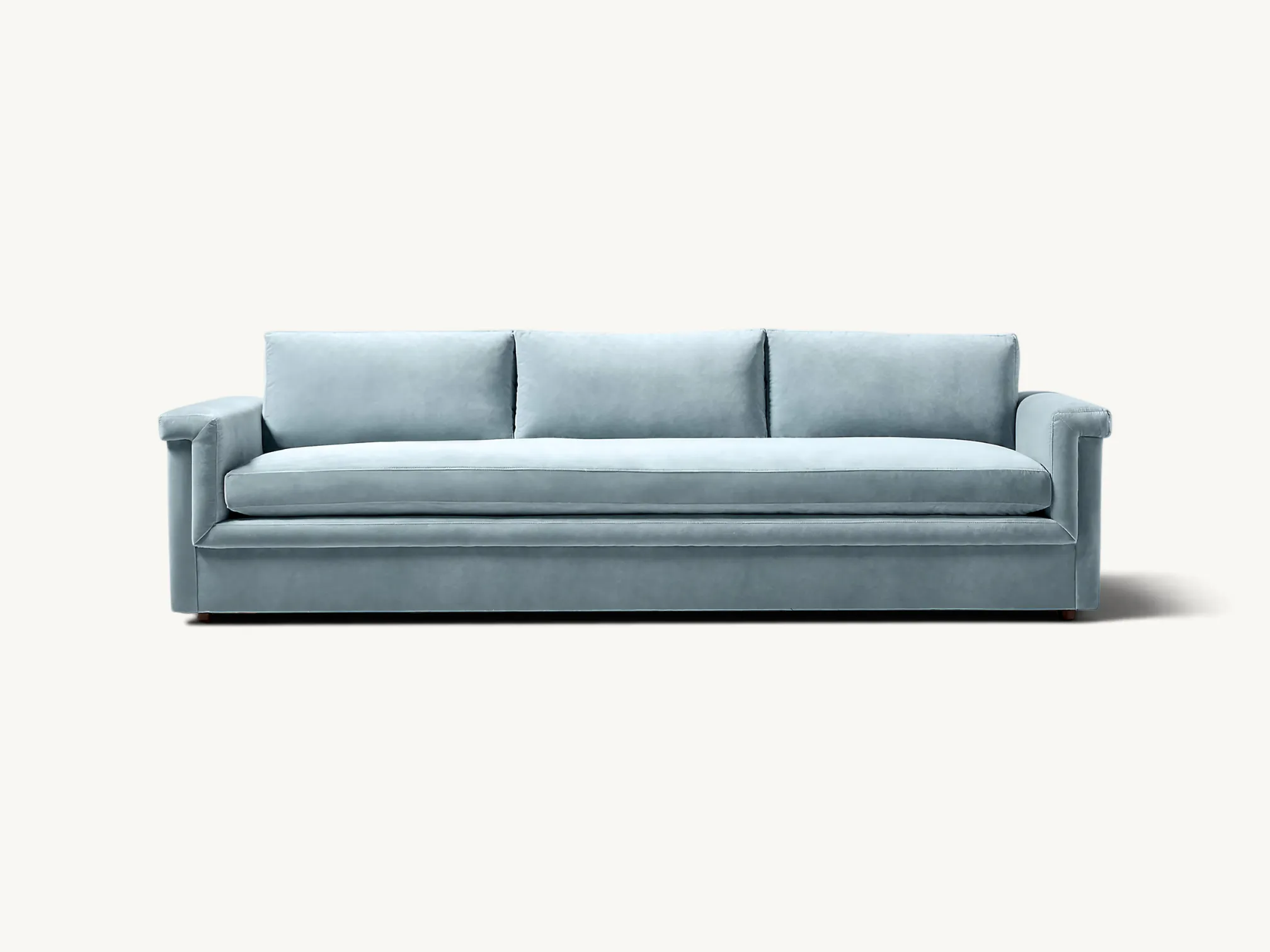 Modern low-profile teak wood sofa with light blue velvet upholstery and long bench seat cushion.