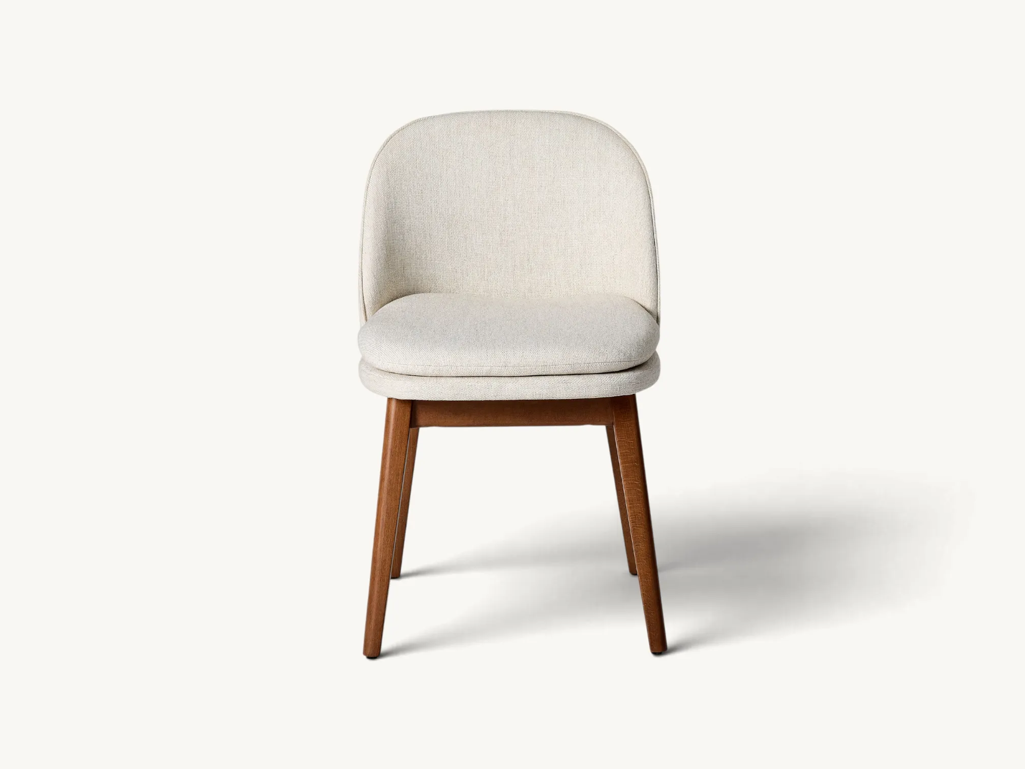 Scandinavian dining chair with solid teak legs and cream fabric upholstery.