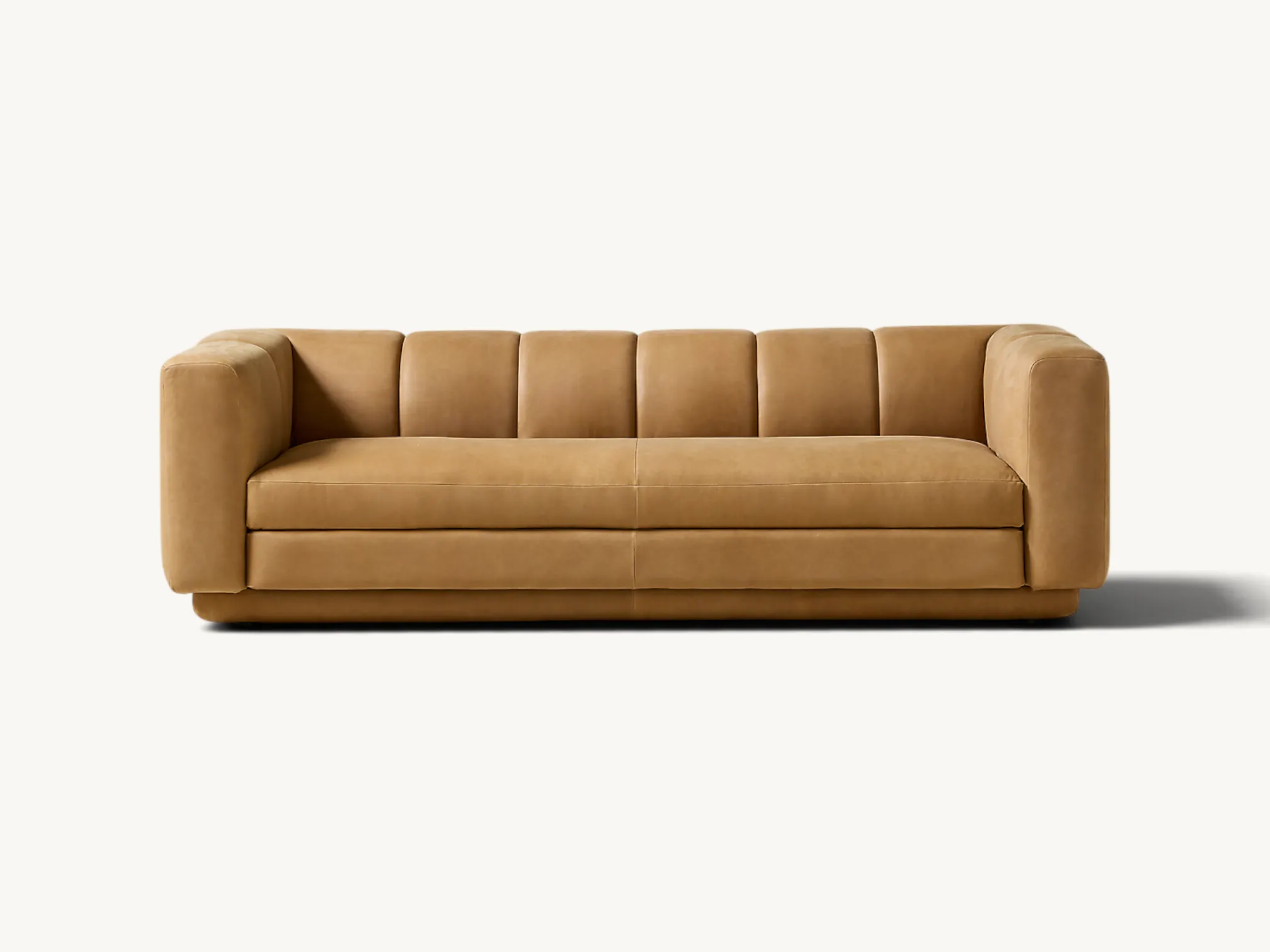 Modern low-profile sofa with vertical channel tufting and textured beige bouclé upholstery.