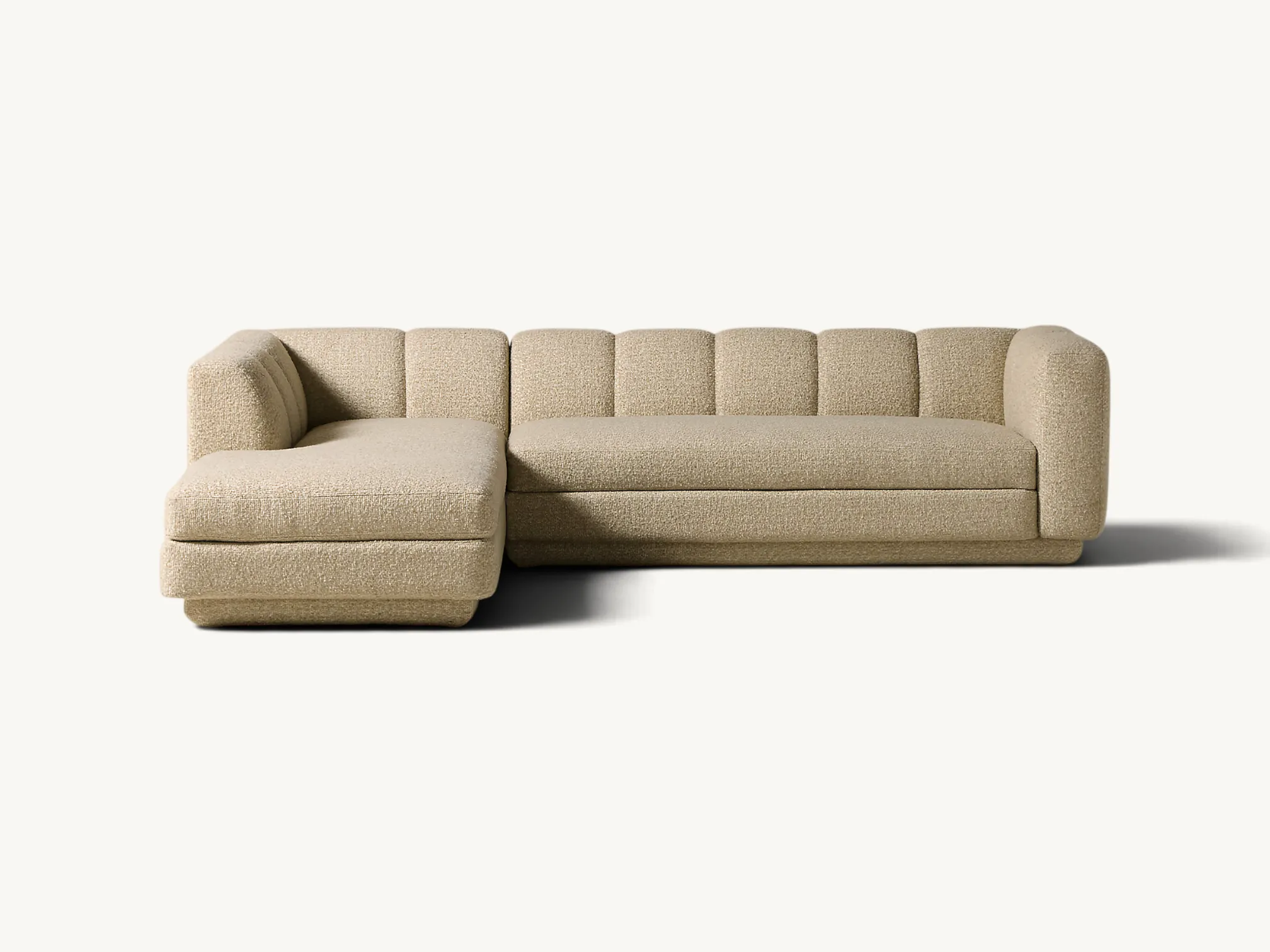 Modern L-shaped sectional sofa with channel tufted backrest and textured beige bouclé upholstery.